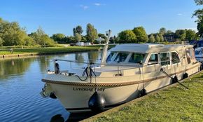 Linssen 35.0 Sedan 2018 boat docked on a serene river with lush greenery.