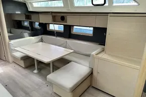 Modern interior of 2023 Beneteau Oceanis 51.1 yacht with sleek dining area and light wood finish.