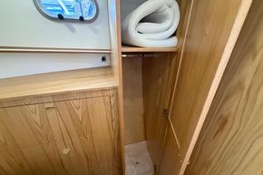 Wooden interior of 2024 Piper 12c boat with storage and rolled mat.