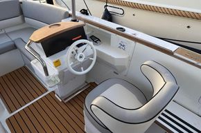 2015 Alfastreet 23 boat interior with steering wheel and cushioned seating.