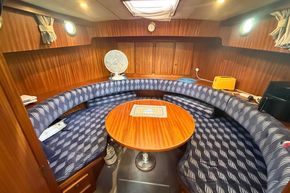Cozy interior of 1994 Linssen 360 AC yacht with circular seating and wooden table.