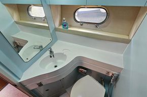 Bathroom interior of 1989 Princess 35 Flybridge yacht with sink and porthole window.