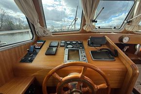 Helm of 1994 Linssen 360 AC yacht with navigation instruments and wooden steering wheel.