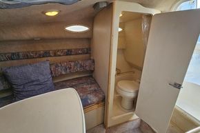 1999 Wellcraft 2400 Martinique cabin interior with seating and compact bathroom.