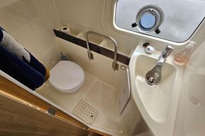 Compact bathroom in 2023 Balt 818 Titanium boat with toilet, sink, and porthole window.