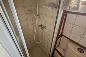 Compact shower area with vintage tiles on a 1926 Dutch Barge Luxemotor.
