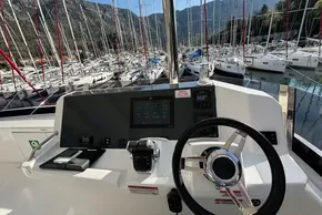 Helm of 2024 Leopard 40 Powercat with marina view and mountainous backdrop.