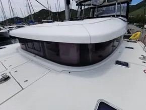 2020 Lagoon 42 catamaran, sleek design, docked in marina with scenic mountain backdrop.