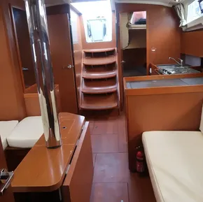 Interior of 2019 Beneteau Oceanis 41.1 yacht with wood finish and compact kitchen.