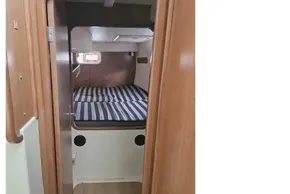 Cozy cabin interior of 2008 Leopard 38 catamaran with striped bedding.