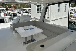 2025 Robertson and Caine Leopard 46 Powercat interior with seating and table in marina setting.