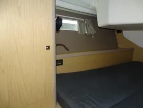 Interior cabin of 2017 Beneteau Oceanis 45 yacht with wooden finish and cozy bed.
