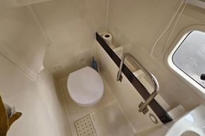 2023 Balt 818 Titanium boat bathroom with toilet, grab rail, and window.