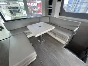 Modern yacht interior with gray seating and a central table, Leopard 50, 2020 model.