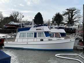 1991 Grand Banks 36 Sedan boat docked at a marina, surrounded by other vessels.