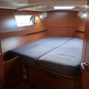 Cozy cabin interior of 2019 Beneteau Oceanis 41.1 sailboat with bed and window.