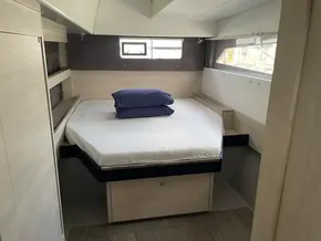 Modern bedroom interior on a 2020 Leopard 50 yacht, featuring a cozy bed and natural light.