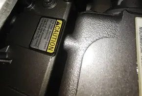 Close-up of 2020 Beneteau Oceanis 46.1 engine components with caution label.