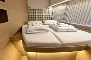 Luxurious cabin interior of 2024 Lagoon 42 catamaran with cozy bedding and ambient lighting.