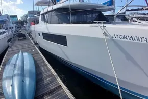 2022 Leopard 45 yacht docked beside a blue kayak on a wooden pier.