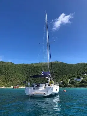 2020 Beneteau Oceanis 46.1 sailboat anchored in scenic bay with lush hills.