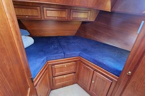 Cozy cabin interior of 2005 Stevens 1200 Vlet with wooden cabinetry and blue bedding.