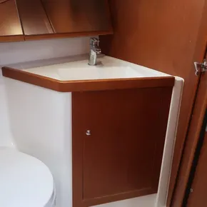 Beneteau Oceanis 41.1 2019 bathroom sink with wooden cabinet and modern faucet.