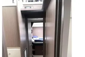 Narrow hallway inside 2022 Leopard 45 yacht, leading to a cozy bedroom.