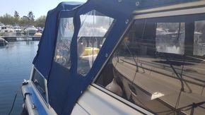 1982 Fairline Mirage 29 Aft Cabin boat docked at marina with blue canopy.
