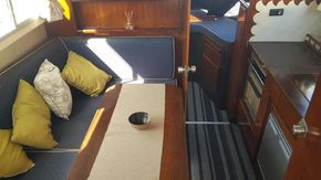 Interior of 1982 Fairline Mirage 29 Aft Cabin with cozy seating and kitchen area.