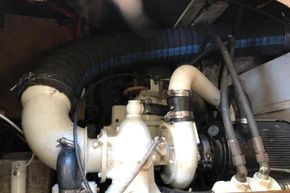 Engine compartment of a 1989 Princess 35 Flybridge boat, featuring hoses and mechanical components.