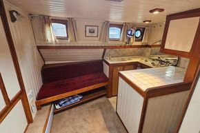 Cozy 1926 Dutch Barge Luxemotor interior with kitchen and seating area.