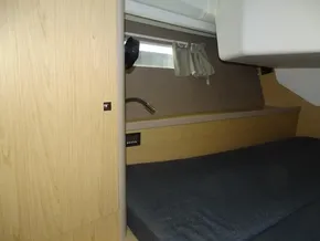 Interior cabin of 2017 Beneteau Oceanis 45 yacht with wooden finish and cozy bed.