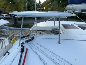 Leopard 40 catamaran deck with ropes and solar panel, docked near palm trees.