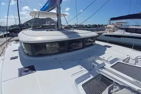 2020 Lagoon 46 catamaran docked at marina under clear blue sky.