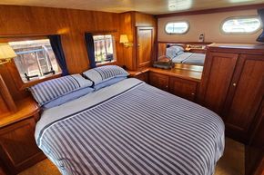 Luxurious cabin interior of 2005 Stevens 1200 Vlet yacht with striped bedding and wooden furnishings.