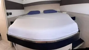 Leopard 50 yacht 2020 model bedroom with a neatly made bed and blue pillows.