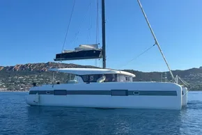 2017 Lagoon 42 catamaran sailing on calm waters with scenic coastal backdrop.