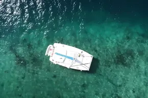 Aerial view of 2008 Leopard 38 catamaran on clear turquoise water.