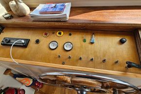 1927 Classic Dutch Barge control panel with gauges, switches, and wooden steering wheel.