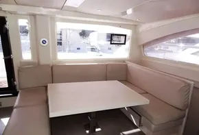 Interior seating area of 2015 Leopard 51 Powercat with large windows and beige upholstery.