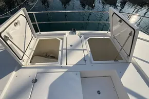 Open storage compartments on 2024 Leopard 40 Powercat deck, reflecting sunlight on water.