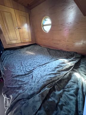 Bedroom berth area with bed, cupboards and storage drawers