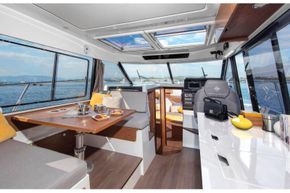 Jeanneau Merry Fisher 1095 - wheelhouse interior with port side saloon seating, starboard side galley and forward pilot + co-pilot seats