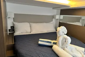 Luxurious cabin interior of 2025 Leopard 46 Powercat with elegant bedding and towel art.