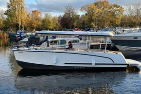 2015 Alfastreet 23 boat on calm water, surrounded by autumn trees and docked boats.