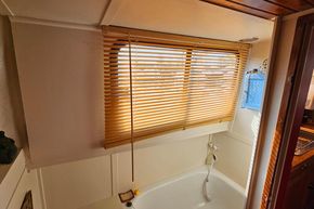 Interior of a 1927 Classic Dutch Barge with wooden blinds and a bathtub.