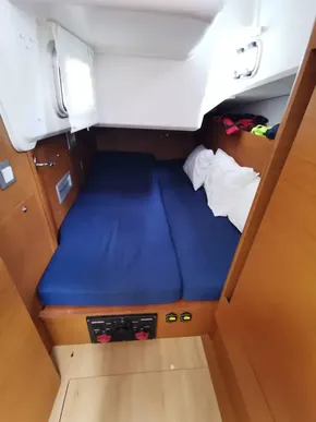 Cozy cabin interior of 2020 Jeanneau Sun Odyssey 410 sailboat with blue bedding.