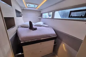 Modern cabin interior of 2021 Leopard 45 yacht with cozy bed and natural light.