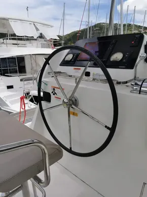Steering wheel of a 2020 Lagoon 42 catamaran at a marina.